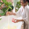 amused model dropping bath bomb in tub